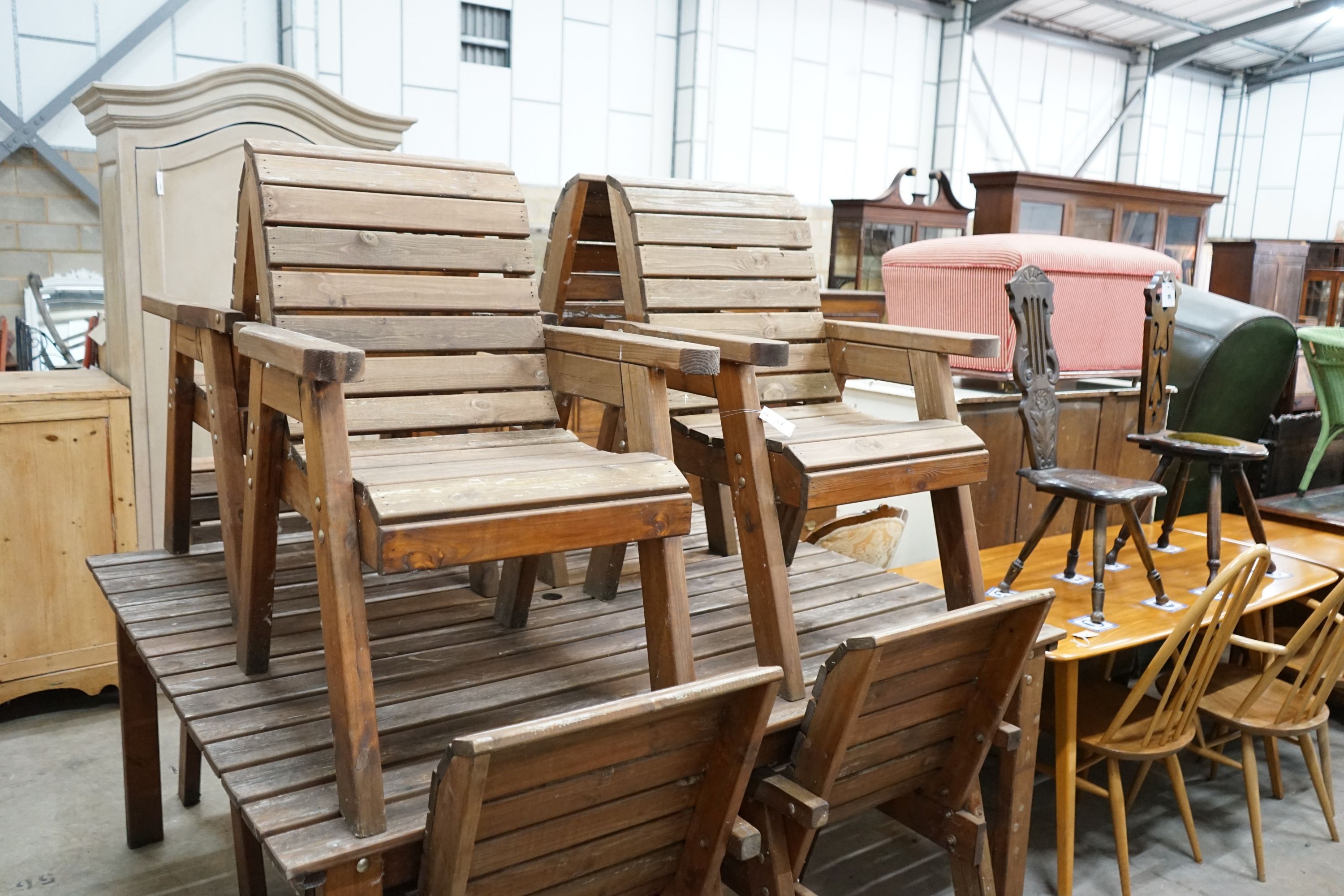 A large rectangular slatted wood garden table, length 174cm, depth 162cm, height 79cm together with eight matching elbow chairs